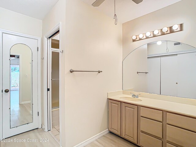 bathroom featuring vanity, hardwood / wood-style flooring, ceiling fan, and a shower with door