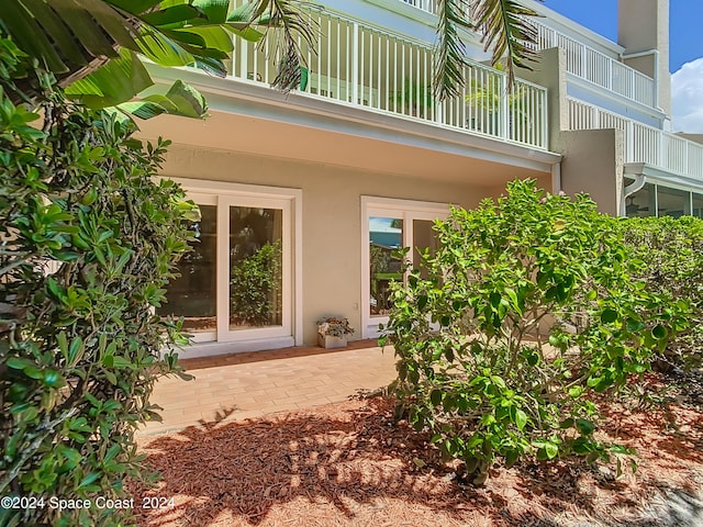 doorway to property featuring stucco siding