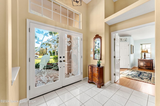 foyer entrance with light wood-type flooring and french doors