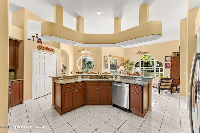 kitchen with dishwasher, ceiling fan, sink, and stone countertops