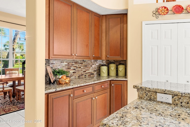 kitchen featuring light tile patterned floors, light stone countertops, and decorative backsplash