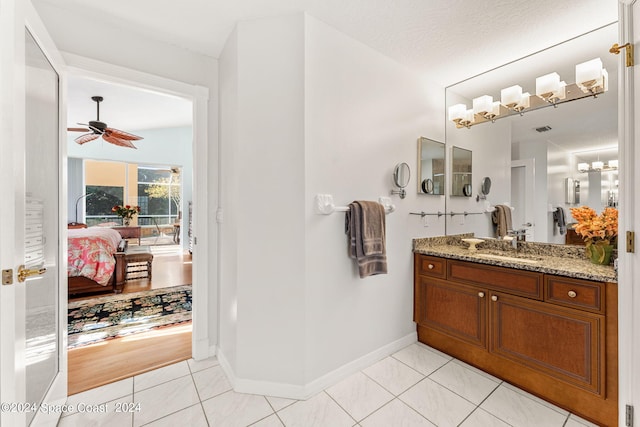 bathroom with tile patterned flooring, ceiling fan, a textured ceiling, and vanity