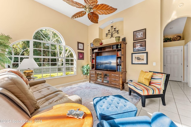 living room with light tile patterned flooring, a high ceiling, and ceiling fan