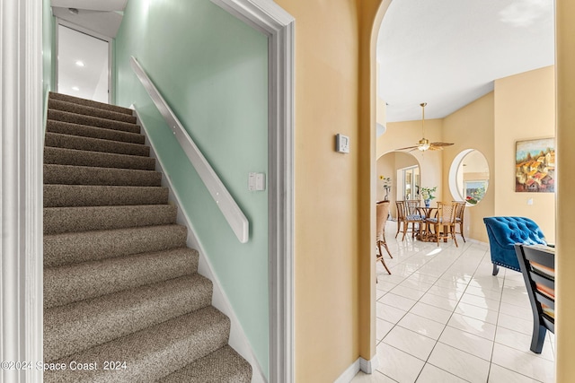 staircase featuring ceiling fan and tile patterned floors