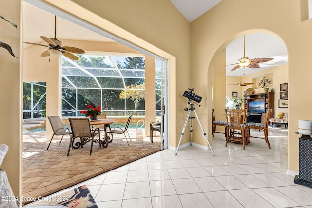 interior space with high vaulted ceiling, ceiling fan, and light tile patterned flooring