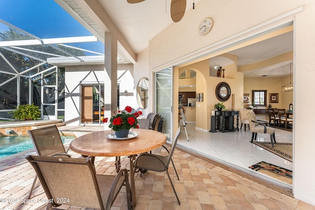 view of patio featuring glass enclosure, pool water feature, and ceiling fan