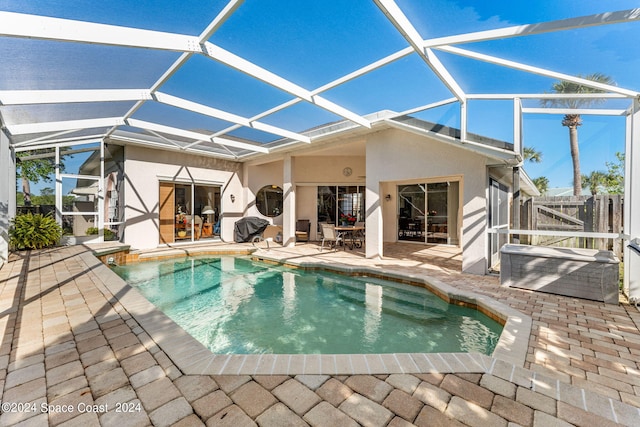 back of house featuring glass enclosure and a patio area