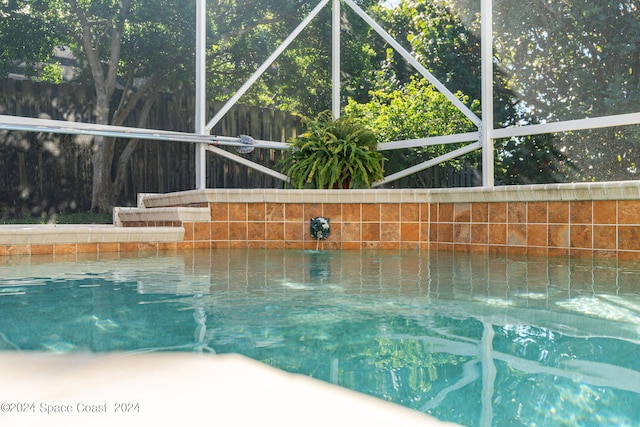 view of pool with pool water feature and a lanai