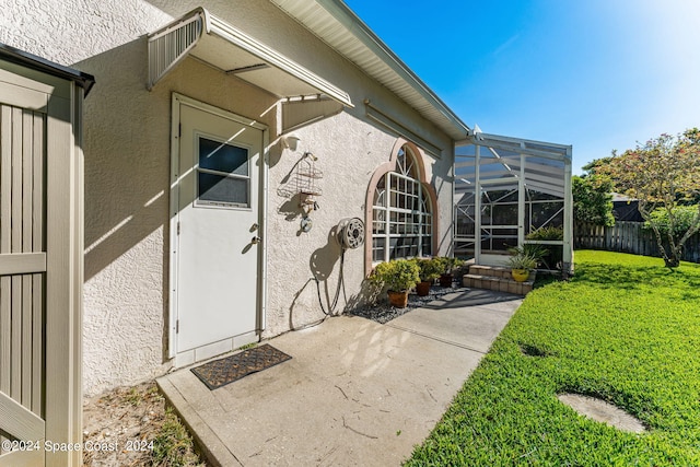 doorway to property featuring a patio area and a lawn