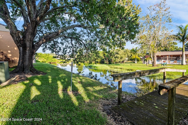 dock area with a water view and a yard