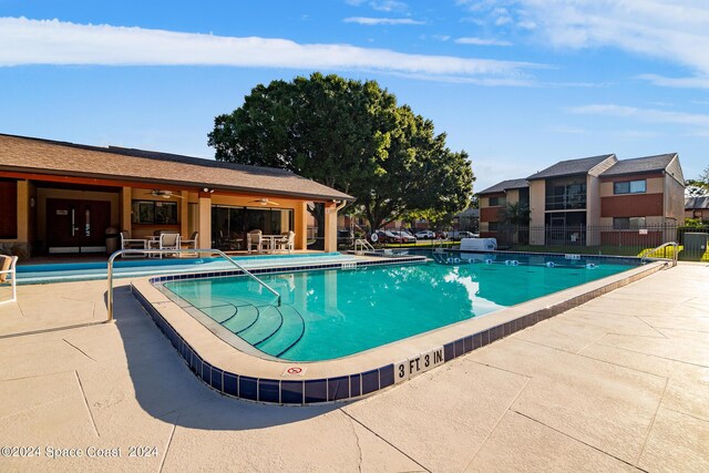 view of swimming pool with a patio area and ceiling fan