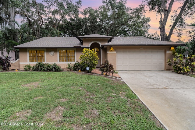 view of front facade with a yard and a garage