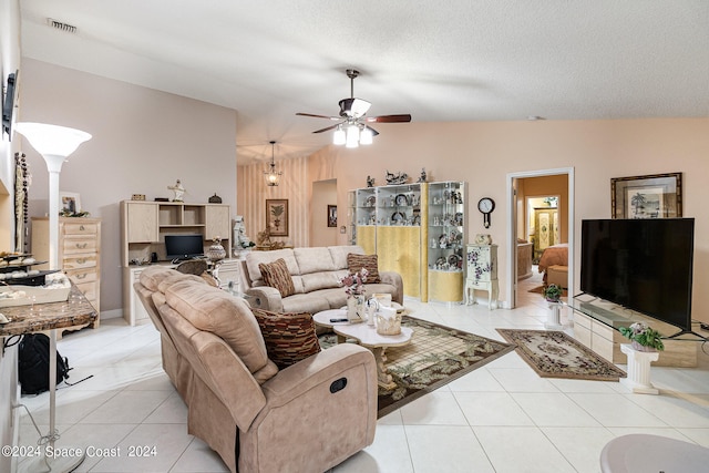 living room featuring ceiling fan, light tile patterned floors, a textured ceiling, and vaulted ceiling