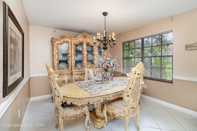 tiled dining room with an inviting chandelier and a textured ceiling