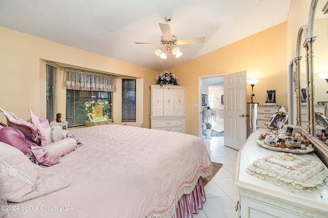 tiled bedroom featuring vaulted ceiling, a textured ceiling, and ceiling fan