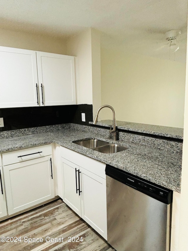 kitchen featuring dishwasher, sink, light hardwood / wood-style flooring, and light stone countertops