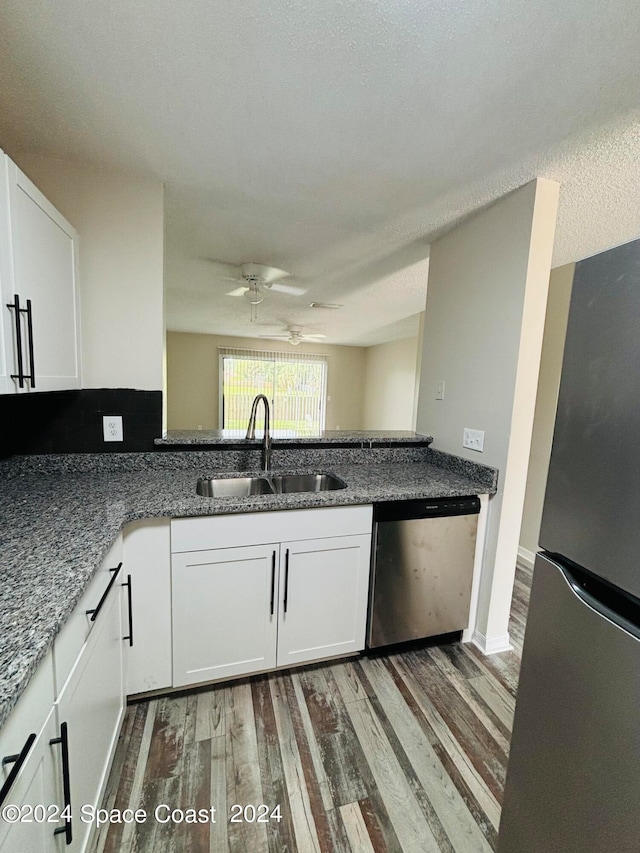 kitchen featuring a textured ceiling, stainless steel appliances, sink, ceiling fan, and hardwood / wood-style flooring