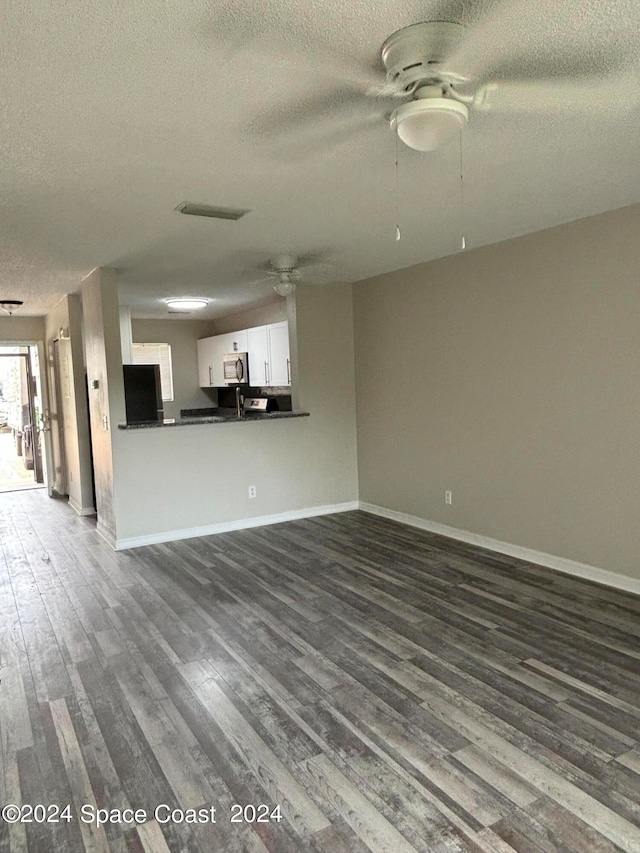 unfurnished living room featuring a textured ceiling, wood-type flooring, and ceiling fan