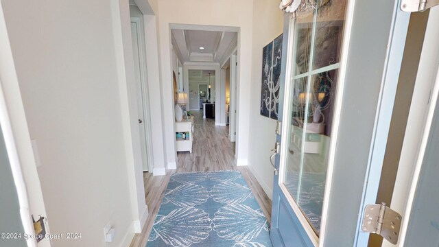 hall with crown molding and light hardwood / wood-style flooring