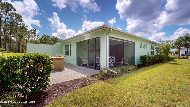 362 Tiki Ter, Daytona Beach, FL 32124 - back of property featuring a sunroom, stucco siding, a yard, and a patio area