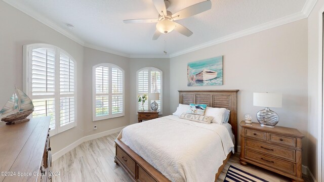 bedroom featuring light wood-type flooring, ornamental molding, and ceiling fan