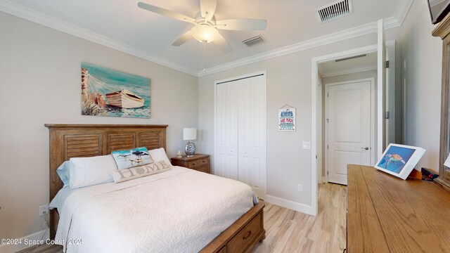 bedroom featuring a closet, ceiling fan, light hardwood / wood-style floors, and crown molding