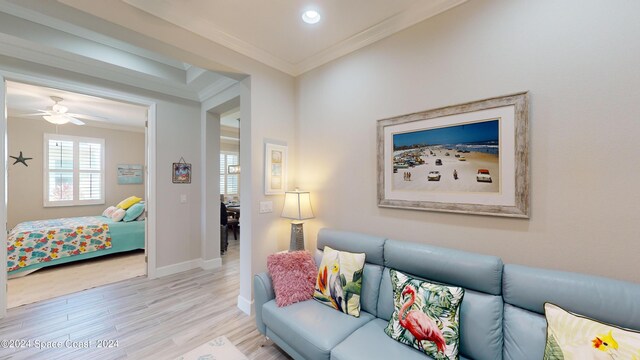 living room with crown molding, ceiling fan, and light hardwood / wood-style floors