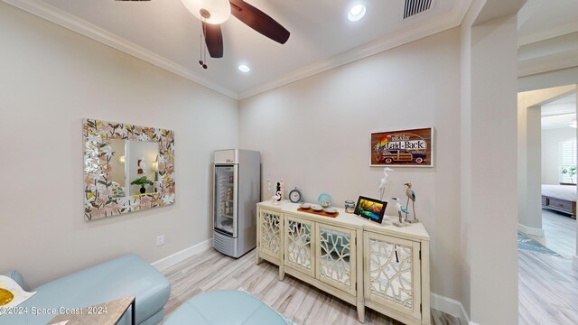 sitting room with ceiling fan, light hardwood / wood-style floors, and ornamental molding