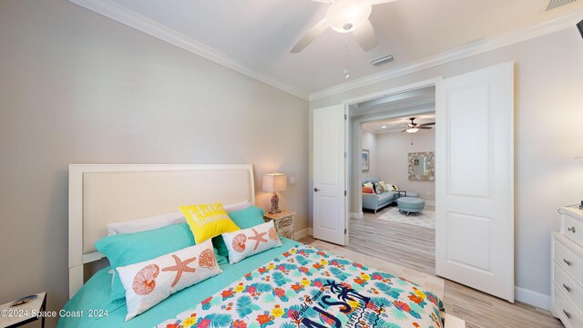 bedroom featuring ceiling fan, crown molding, and light hardwood / wood-style flooring