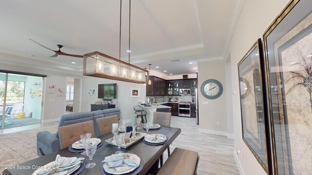 dining area featuring ornamental molding, light wood-type flooring, and ceiling fan