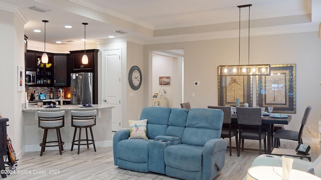 362 Tiki Ter, Daytona Beach, FL 32124 - living area featuring indoor wet bar, a tray ceiling, light wood finished floors, and crown molding