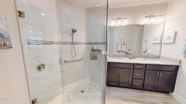 bathroom with crown molding, vanity, wood-type flooring, and walk in shower