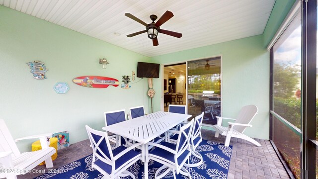 sunroom / solarium featuring ceiling fan