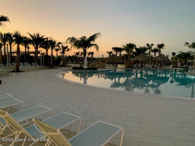 pool at dusk featuring a patio