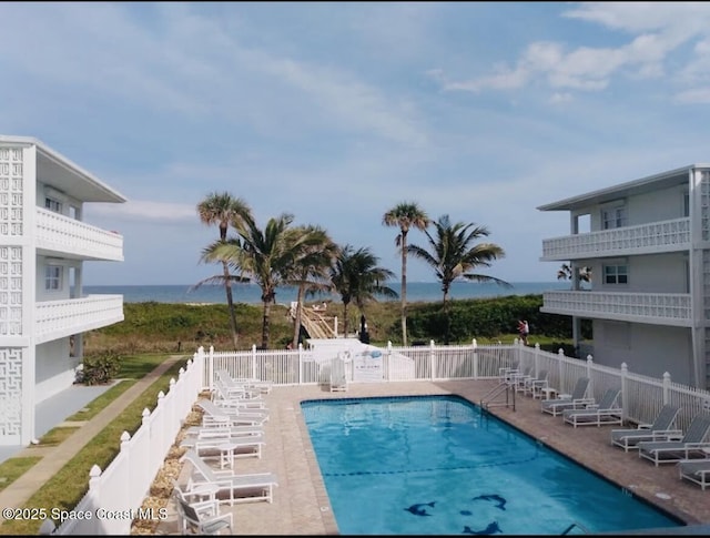 view of pool with a water view and a patio area