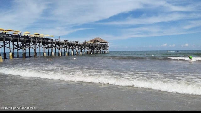 dock area with a water view and a view of the beach