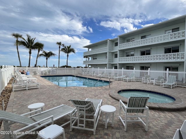 view of swimming pool featuring a hot tub and a patio