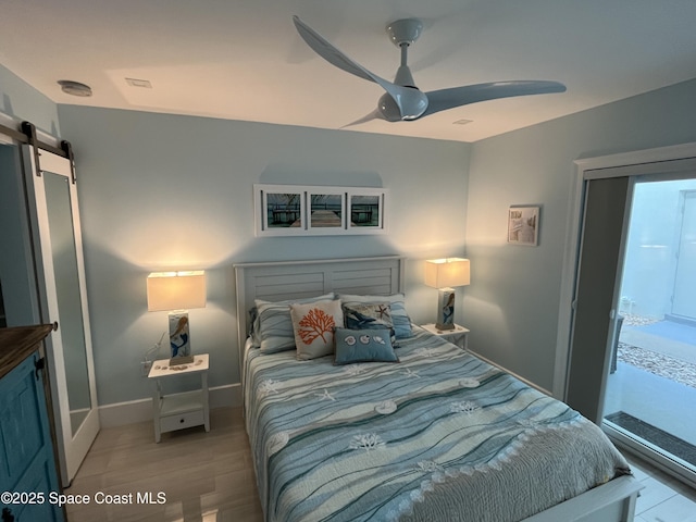 bedroom with a barn door and ceiling fan