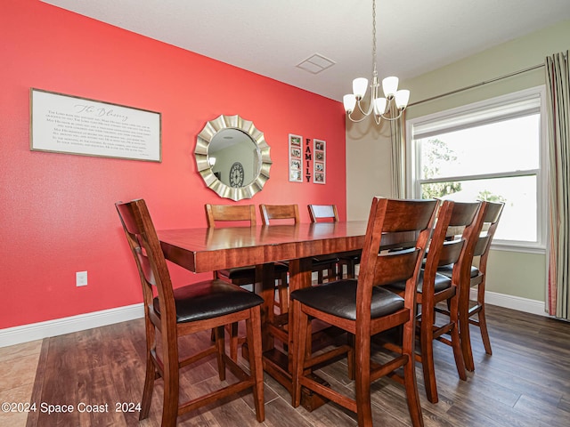 dining area featuring dark wood-type flooring and a chandelier