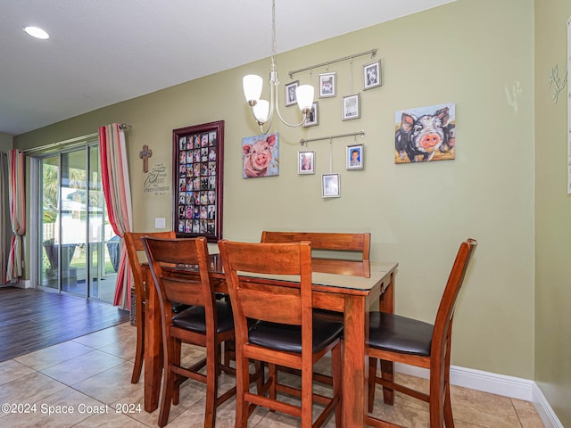 dining area with light hardwood / wood-style flooring and a chandelier