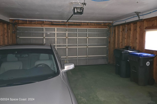 garage with a garage door opener and wooden walls