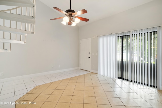 tiled spare room featuring ceiling fan and vaulted ceiling