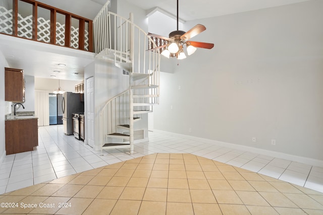 staircase featuring high vaulted ceiling, sink, ceiling fan, and tile patterned flooring