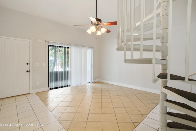 tiled empty room with vaulted ceiling and ceiling fan