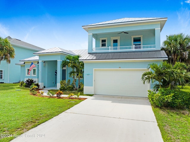 beach home with ceiling fan, a front yard, and a garage