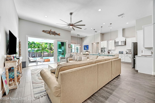 living room featuring ceiling fan and light hardwood / wood-style flooring