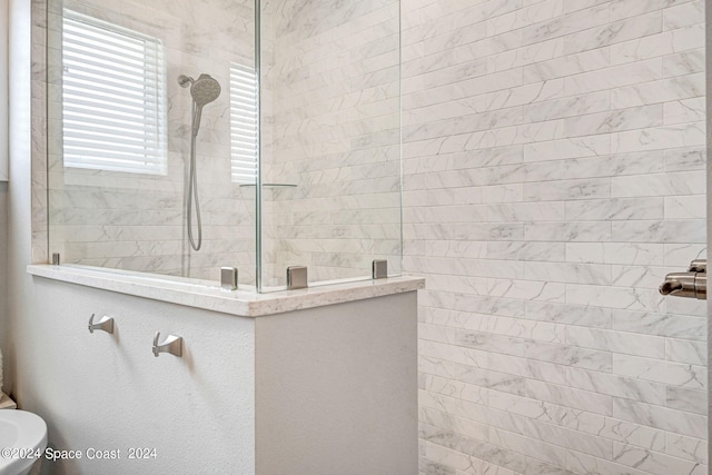 bathroom featuring a tile shower and toilet