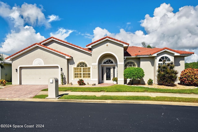 mediterranean / spanish-style house with a garage