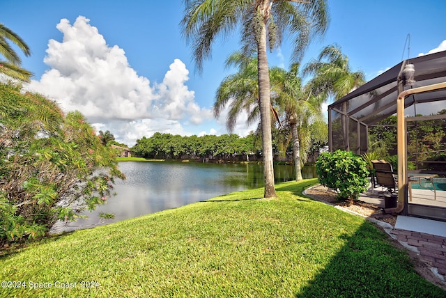 view of yard with a water view and glass enclosure