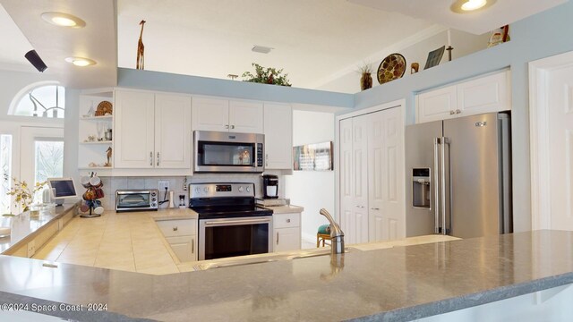 kitchen featuring crown molding, tasteful backsplash, stainless steel appliances, kitchen peninsula, and white cabinets